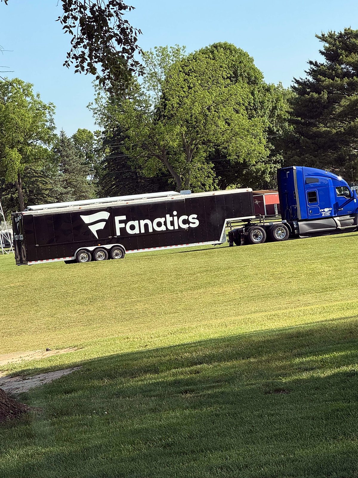 Trailer and blue tractor on a grass lot